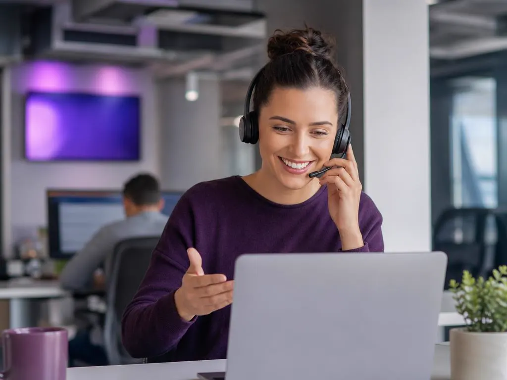 Support specialist with a headset helping a customer on a laptop