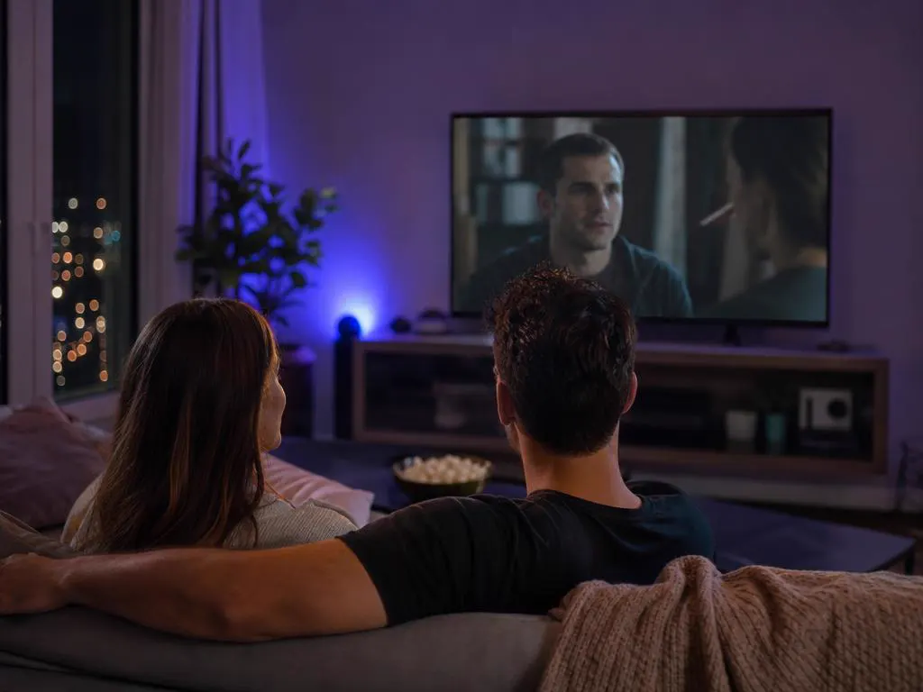 Couple watching a dramatic series on TV in the evening