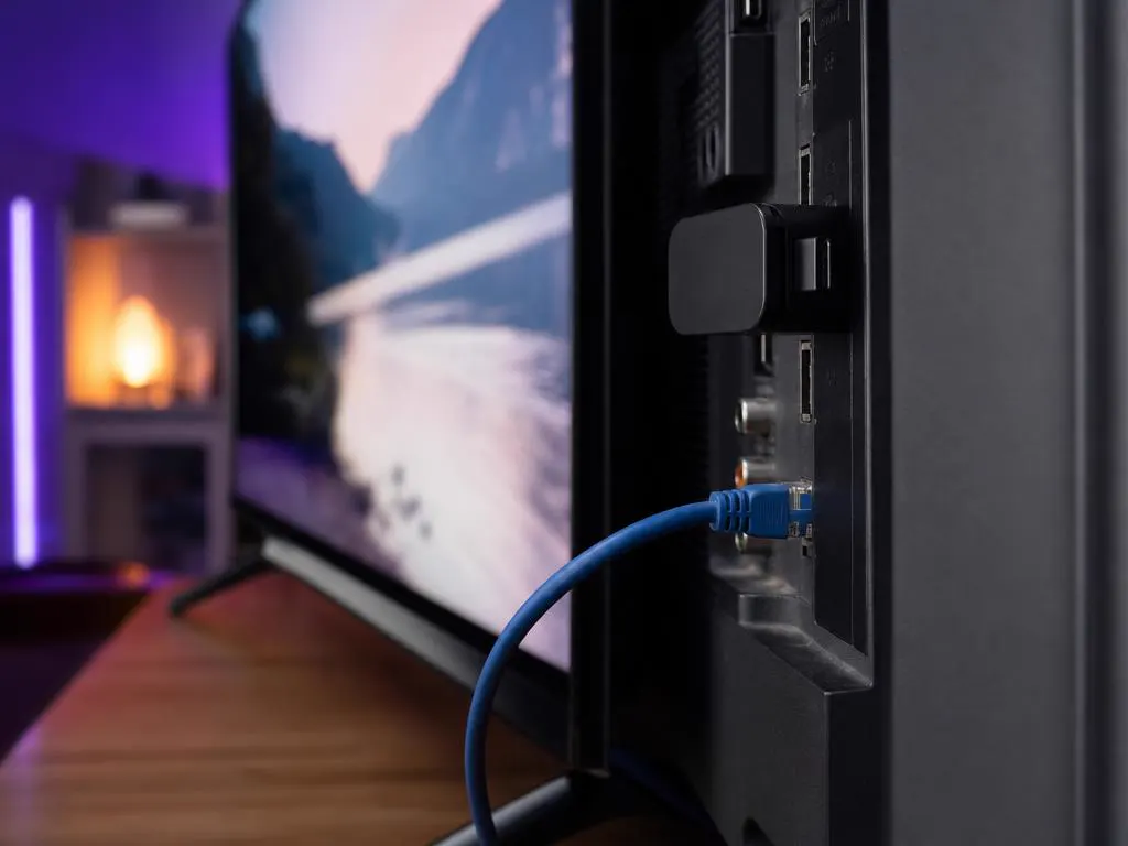 Câble Ethernet branché à l’arrière d’une TV équipée d’une clé de streaming