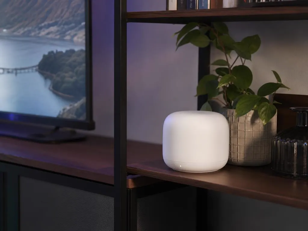Point Wi-Fi maillé posé sur une étagère près de la TV du salon