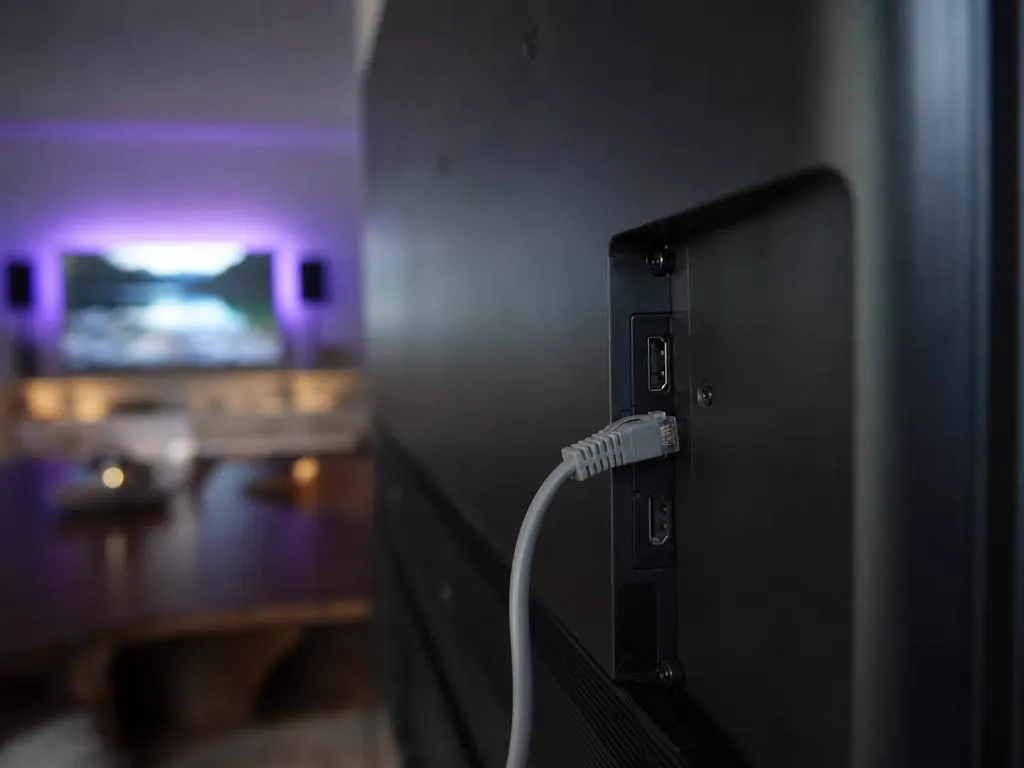 Câble Ethernet branché à l’arrière d’une Smart TV fine