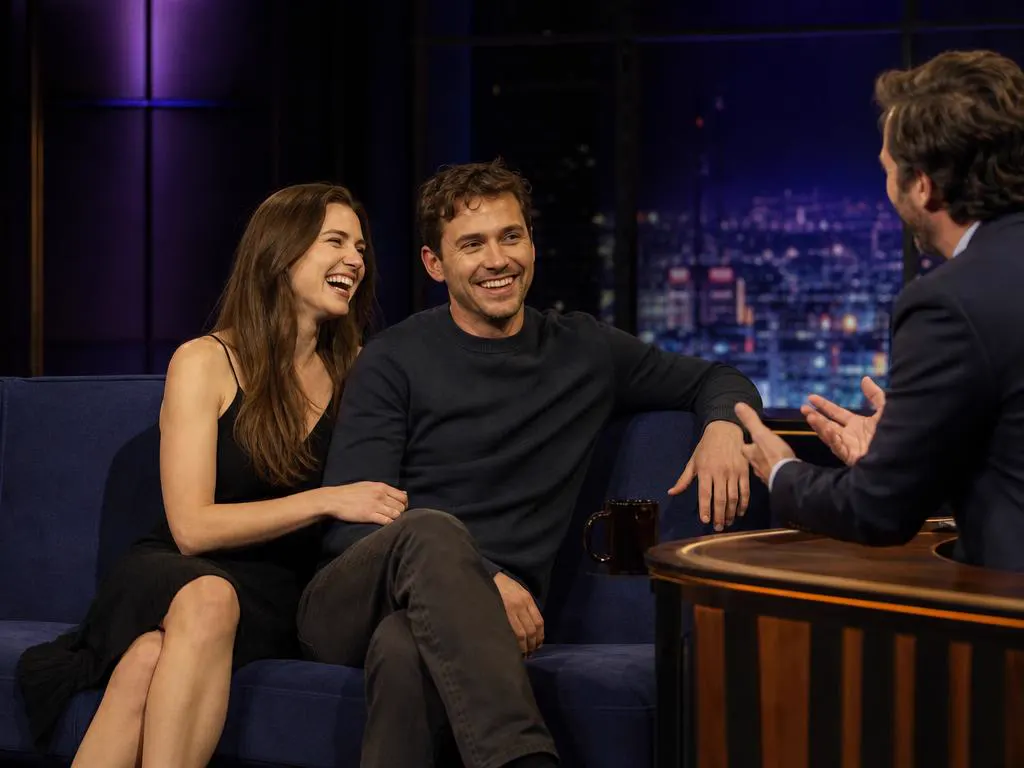Couple laughing at a late-night talk show on TV
