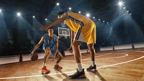 Basketteur qui dribble un défenseur dans une salle comble pendant un match en direct