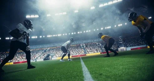 Joueurs de football américain alignés sous les projecteurs d’un stade pendant un match en direct