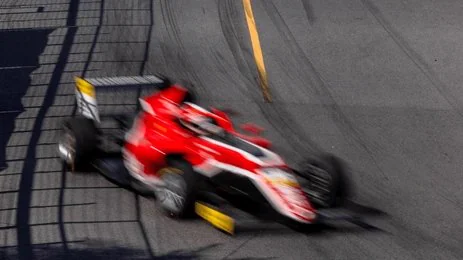 Monoplace rouge lancée dans un virage pendant un week-end de course en direct