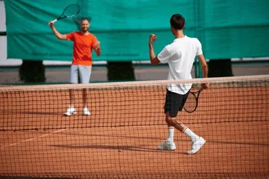 Joueurs de tennis qui célèbrent un point sur terre battue pendant un match en direct